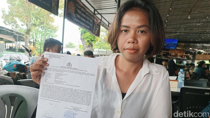 Rani Veronica Napitupulu (29) menunjukkan bukti pelaporan terhadap adik iparnya R. (Goklas Wisely/detikSumut)