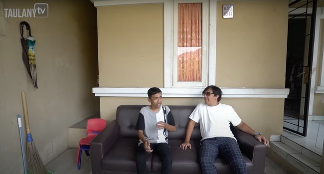 Rumah tipe 70 milik Dede tampak didominasi dengan warna coklat. Di bagian teras depan rumahnya terdapat sebuah sofa yang bisa dipakai untuk bersantai atau mengobrol. Foto: YouTube/Taulany TV
