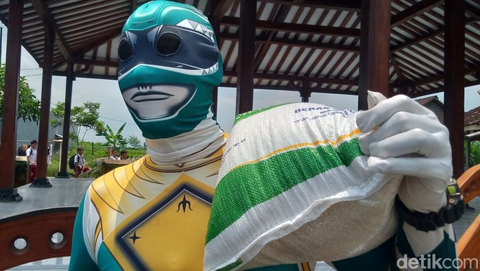 Sarijo, warga Desa Tambakan, Kecamatan Jogonalan, Kabupaten Klaten, mengambil beras bantuan 10 kg dengan kostum superhero ala Power Rangers, Selasa (20/2/2024).