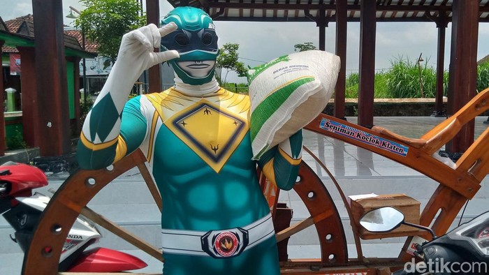 Sarijo, warga Desa Tambakan, Kecamatan Jogonalan, Kabupaten Klaten, mengambil beras bantuan 10 kg dengan kostum superhero ala Power Rangers, Selasa (20/2/2024).