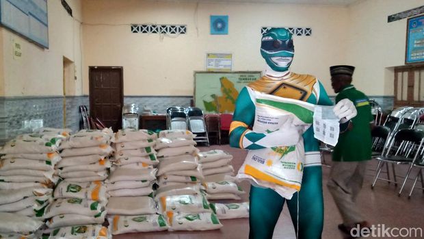 Sarijo, warga Desa Tambakan, Kecamatan Jogonalan, Kabupaten Klaten, mengambil beras bantuan 10 kg dengan kostum superhero ala Power Rangers, Selasa (20/2/2024).