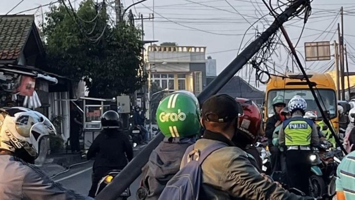 Tiang berkabel di Jalan Raya KSU, Sukmajaya, Depok, Jawa Barat (Jabar) roboh pagi tadi. Lalu lintas (lalin) di lokasi sempat mengalami kemacetan. (dok ist)