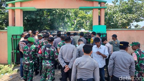 TNI-Polri melakukan penjagaan di pintu gerbang (pintu masuk) area kantor Camat Woja Selasa (20/2/2024). (Faruk Nickyrawi)