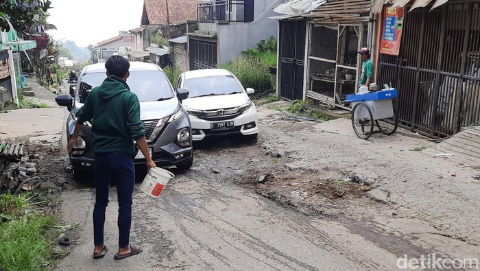 Warga Atur Lalu Lintas di Jalan Sersan Bajuri yang Rusak Parah