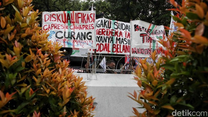 Massa yang tergabung dalam Poros Buruh melakukan unjuk rasa di depan gedung KPU, Jakarta Pusat, Rabu (21/2/2024).
