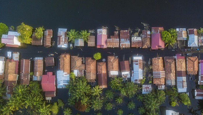 Seorang warga berjalan di depan rumahnya yang terendam banjir di Desa Sungai Bungur, Muaro Jambi, Jambi, Selasa (20/2/2024). Banjir yang menggenangi ratusan rumah akibat meluapnya Sungai Batanghari yang telah berlangsung lebih dari delapan minggu tersebut menghambat aktivitas warga serta peniadaan kegiatan sekolah secara tatap muka tersebut. ANTARA FOTO/Wahdi Septiawan/wpa.