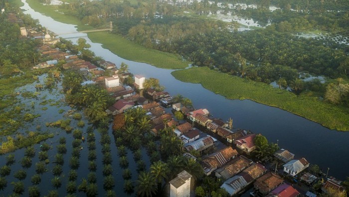 Banjir luapan Sungai Batanghari di Muaro Jambi Seorang warga berjalan di depan rumahnya yang terendam banjir di Desa Sungai Bungur, Muaro Jambi, Jambi, Selasa (20/2/2024). Banjir yang menggenangi ratusan rumah akibat meluapnya Sungai Batanghari yang telah berlangsung lebih dari delapan minggu tersebut menghambat aktivitas warga serta peniadaan kegiatan sekolah secara tatap muka tersebut. ANTARA FOTO/Wahdi Septiawan/wpa.