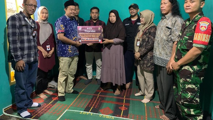 Komisioner KPU Purbalingga, Widyo Wibowo memberikan santunan kepada ahli waris petugas linmas yang meninggal dunia usai berjaga di TPS 07 Desa Karanglewas, Kecamatan Kutasari, Kabupaten Purbalingga, Rabu (21/2/2024).