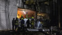 Jendela dan bagian dalam toko di gedung apartemen di seberang lokasi kejadian rusak.