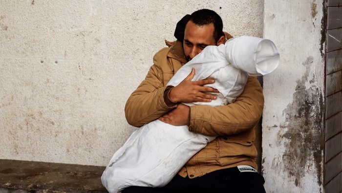 A Palestinian man reacts next to the body of his daughter who was killed in an Israeli strike, amid the ongoing conflict between Israel and Hamas, at Abu Yousef Al-Najjar hospital, in Rafah, in the southern Gaza Strip, February 21, 2024. REUTERS/Ibraheem Abu Mustafa
