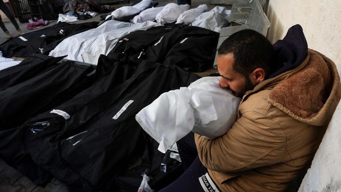 A Palestinian man reacts next to the body of his daughter who was killed in an Israeli strike, amid the ongoing conflict between Israel and Hamas, at Abu Yousef Al-Najjar hospital, in Rafah, in the southern Gaza Strip, February 21, 2024. REUTERS/Ibraheem Abu Mustafa