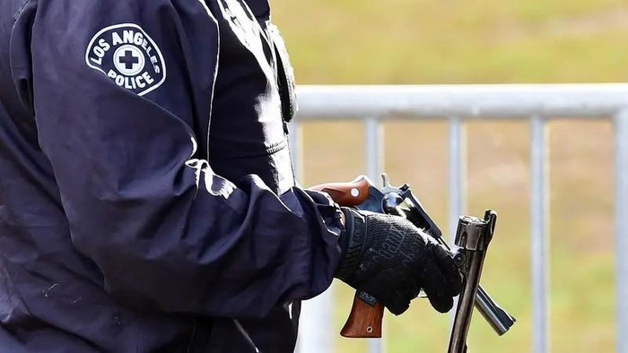A Los Angeles Police Department officer holds recovered guns. (File photo: AFP)