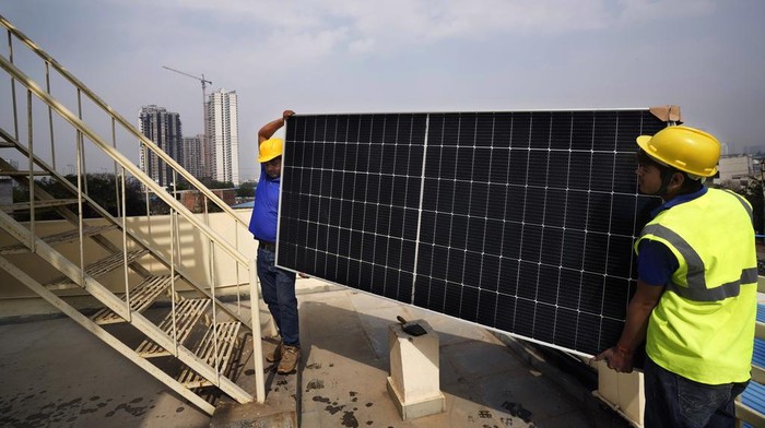 Workers of Solar Square put up a panel on the rooftop of a residence in Gurugram on the outskirts of New Delhi, India, Tuesday, Feb. 20, 2024. India is renewing its push to add rooftop solar to meet the needs of a fast-growing nation that's hungry for energy. (AP Photo/Manish Swarup)