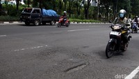 Seorang pengendara sedang melintas Jalan Ahmad Yani yang berlubang.