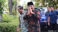 Keduanya menggunakan batik, Mahfud dengan nuansa tosca, sedangkan Hadi mengenakan batik berwarna dasar hitam dengan corak corak.