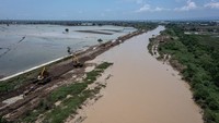 Foto udara pekerja mengoperasikan alat berat menyelesaikan penguatan tanggul Sungai Wulan yang sempat jebol akibat tak mampu menampung debit air di Kecamatan Karanganyar, Kabupaten Demak, Jawa Tengah, Rabu (21/2/2024).