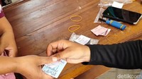 Seorang warga sedang menukarkan  kupon untiuk medapatkan beras murah seharga Rp 51 ribu per 5 kilogram.