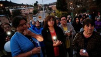 Orang-orang berkumpul dan menyalakan senter di ponsel mereka untuk mengenang para korban yang meninggal akibat meluasnya kebakaran hutan di lingkungan El Olivar di Vina del Mar, Chili 22 Februari 2024.  