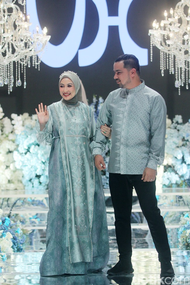 Pasangan selebriti Annisa Trihapsari dan Sultan Djorghi juga memperagakan koleksi sarimbit bahan silk bernuansa sage yang mencuri atensi. Foto: Mohammad Abduh/detikcom.