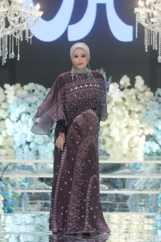 Membawakan koleksi Lebaran 2024 yang bertajuk Crystabela, Adelia Pasha mengenakan dress motif kristal warna burgundy. Dilengkapi dengan headpiece dan kalung. Foto: Mohammad Abduh/detikcom.