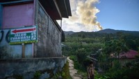Pelajar berangkat ke sekolah saat Gunung Marapi mengeluarkan abu vulkanik terlihat dari Jorong Batang Silasiah, Nagari Bukik Batabuah, Agam, Sumatera Barat. 