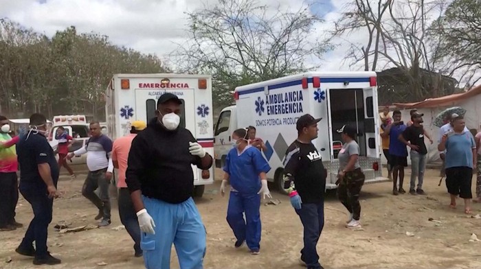 Proses Evakuasi Korban Tewas Tambang Emas Runtuh di Venezuela Ambulances are parked at Guacara River Port following the collapse of an illegal gold mine in La Paragua, Bolivar, Venezuela February 21, 2024. REUTERS TV via REUTERS