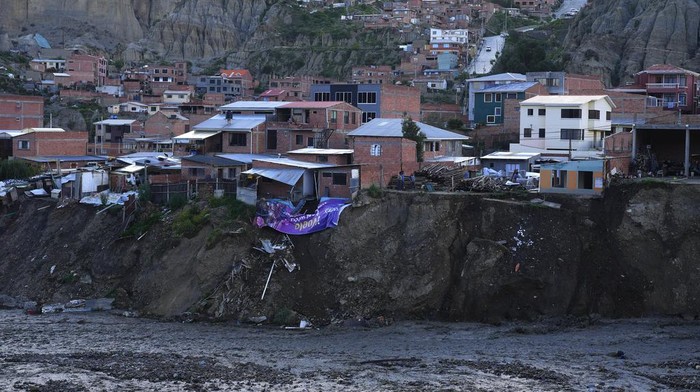 Puluhan Rumah di Bantaran Sungai Bolivia Runtuh Tergerus Longsor Municipal workers use heavy equipment to remove sludge from a riverbed, where a mudslide due to persistent rains damaged several homes on the banks of the Irpavi 2 river, in La Paz, Bolivia, Thursday, Feb. 22, 2024. (AP Photo/Juan Karita)