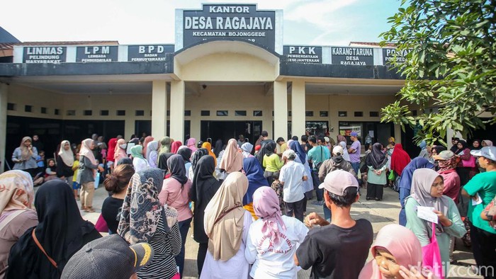 Pembagian bantuan Cadangan Beras Pemerintah (CBP) dilakukan di Kantor Desa Ragajaya, Kabupaten Bogor, Jumat (23/2/2024). Warga mengantre panjang.