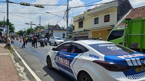 Petugas menjaga lokasi ceceran oli di Jalan Flamboyan Klungkung, Sabtu (24/2/2024). (foto : Putu Krista/ detikBali).