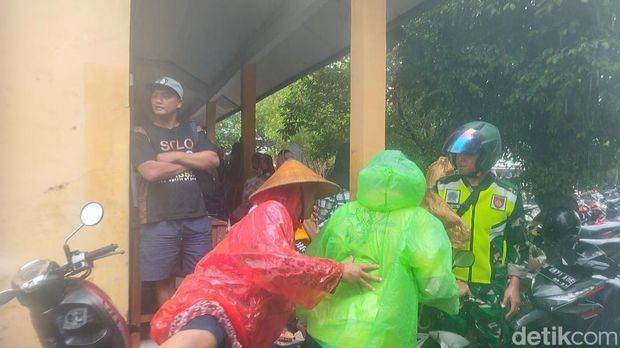 Warga terjang banjir dan hujan untuk mencoblos susulan di SDN Wonorejo 1, Karanganyar, Demak, Sabtu (24/2/2024).