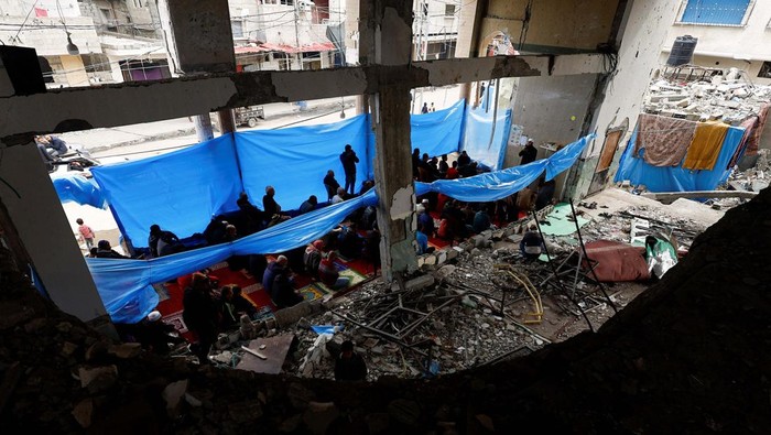 A Palestinian man performs Friday prayers at the ruins of a mosque destroyed in Israeli strikes, amid the ongoing conflict between Israel and Hamas, in Rafah in the southern Gaza Strip February 23, 2024. REUTERS/Mohammed Salem