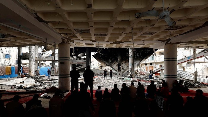 A Palestinian man performs Friday prayers at the ruins of a mosque destroyed in Israeli strikes, amid the ongoing conflict between Israel and Hamas, in Rafah in the southern Gaza Strip February 23, 2024. REUTERS/Mohammed Salem