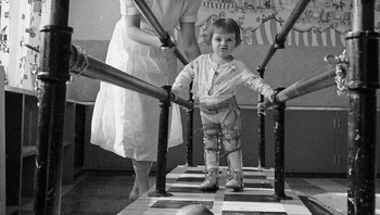 Seorang anak kecil yang sedang latihan berjalan di rumah sakit perawatan penyakit polio pada tahun 1953. Foto: Boredpanda