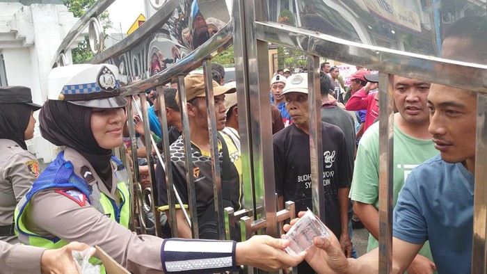 Momen Polwan bagikan minuman kepada para pendemo penundaan Pilkades di Banjarnegara.