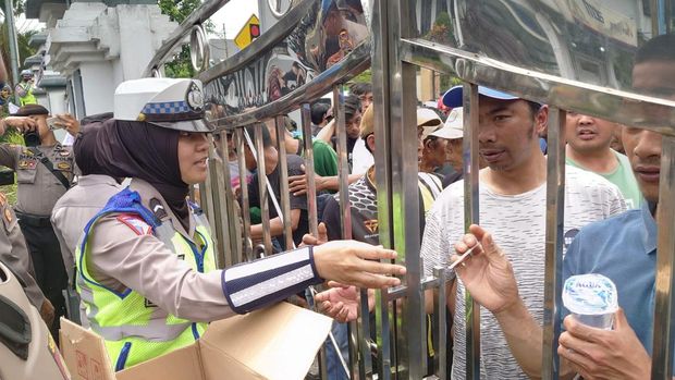 Momen Polwan bagikan minuman kepada para pendemo penundaan Pilkades di Banjarnegara.
