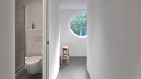 Di bagian lantai 2 ada kamar mandi dan kamar tidur. Bagian kamar mandi terlihat minimalis dan tampak ada toilet duduk. Foto: Jeroen Musch via Dezeen
