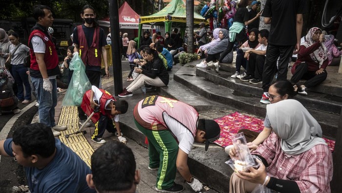 Sejumlah anak dari Yayasan Yatim Mandiri membersihkan sampah saat berlangsungnya hari bebas kendaraan bermotor (HBKB) di kawasan Bundaran HI, Jakarta, Minggu (25/2/2024). Komunitas Operasi Semut bersama Yayasan Yatim Mandiri menggelar kegiatan bersih-bersih sampah saat HBKB atau car free day (CFD) dalam rangka memperingati Hari Peduli Sampah Nasional. ANTARA FOTO/Aprillio Akbar/aww.