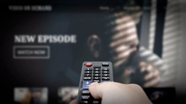 Ilustrasi Nonton Film VOD service on television. Man watching TV, streaming service, video on demand, remote control in hand.