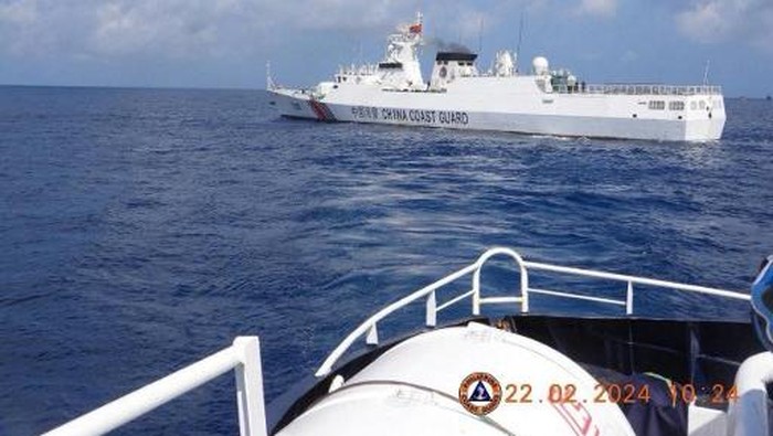This handout photo taken on February 22, 2024 and received on February 25, 2024 from the Philippine Coast Guard shows a China Coast Guard vessel sailing near the BRP Datu Sanday during their mission to bring supplies to fishermen near the China-controlled Scarborough Shoal in the disputed South China Sea. The Philippines on February 25 accused the Chinese coast guard of attempting to block the Filipino government vessel BRP Datu Sanday delivering supplies to fishermen, the second such alleged incident near a disputed reef in two weeks. (Photo by Handout / Philippine Coast Guard (PCG) / AFP) / RESTRICTED TO EDITORIAL USE - MANDATORY CREDIT 