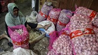 Para pekerja mengupas bawang putih di Pasar Senen, Jakarta Pusat, Minggu (25/2/2024).