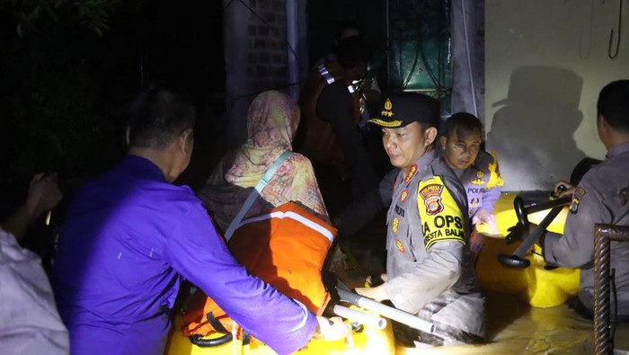 Petugas mengevakuasi warga yang terjebak banjir di Bandar Lampung.