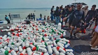 Para peserta yang mencapai garis finis mengumpulkan pelampung, setelah berenang di Selat Madura sepanjang 4,6 kilometer.