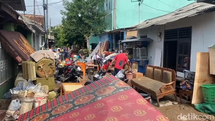 Warga membersihkan perabotan rumah pasca banjir..