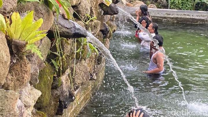 Wisatawan menikmati wisata spiritual di tempat penglukatan Pura Pesiraman Desa Aan, Klungkung, Minggu (18/2/2024). (Putu Krista/detikBali)