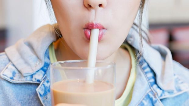 close up asian woman mouth enjoy drink taiwanese drink bubble milk tea in glass - she chew and stir tapioca pearls