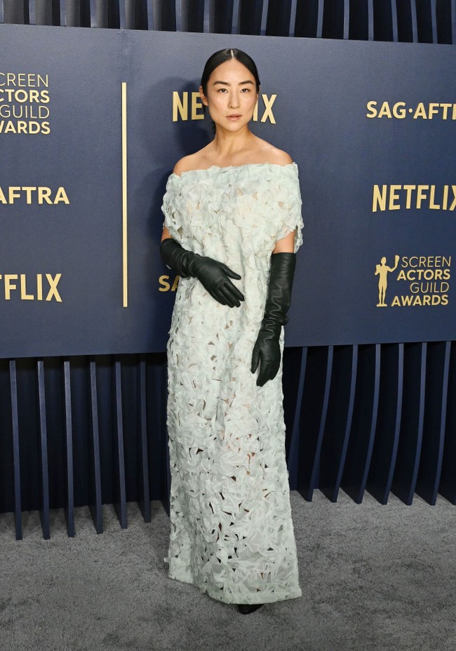 Show your shoulder. Greta Lee berbalut gaun off-sholder keluaran The Row yang dipadu dengan opera gloves hitam yang kontras. (Foto: Gilbert Flores/Variety via Getty Images)