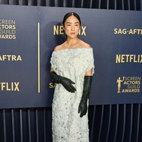 Show your shoulder. Greta Lee berbalut gaun off-sholder keluaran The Row yang dipadu dengan opera gloves hitam yang kontras. (Foto: Gilbert Flores/Variety via Getty Images)