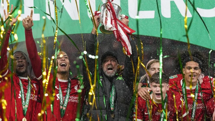 Liverpools manager Jurgen Klopp lifts the trophy next to Liverpools Virgil van Dijk as the team celebrates winning the English League Cup final soccer match between Chelsea and Liverpool at Wembley Stadium in London, Sunday, Feb. 25, 2024. (AP Photo/Alastair Grant)
