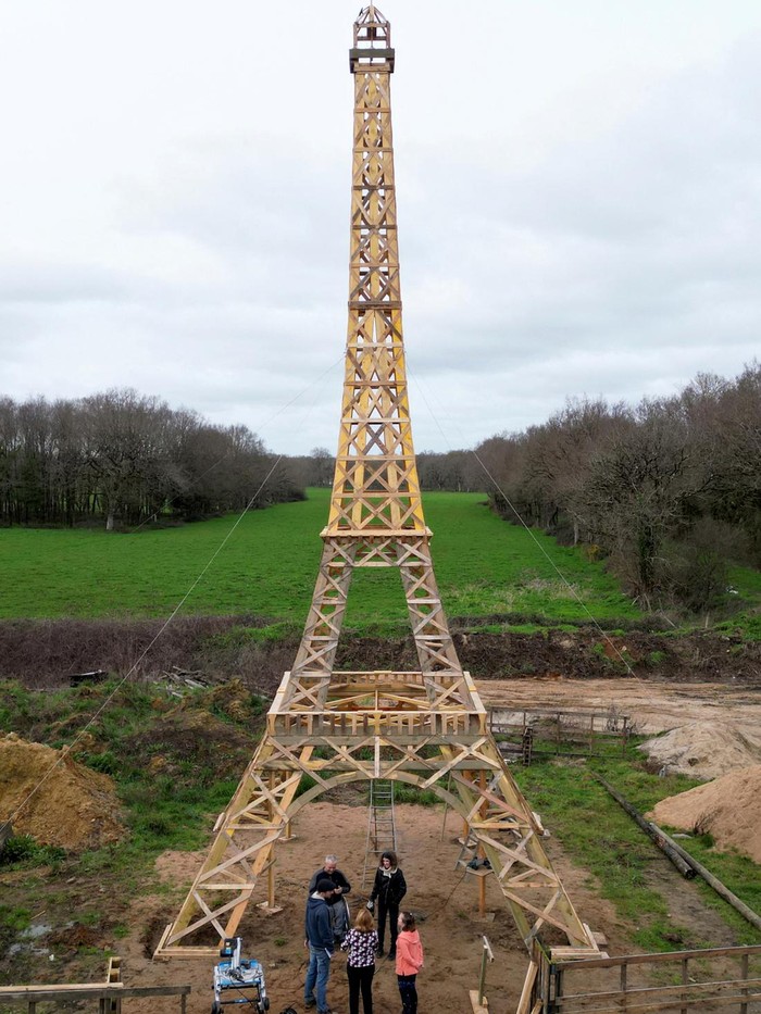 French carpenter Frederic Malmezac and Sylvain Bouchard, a sports enthusiast with disability, work on a 16-meter replica of the Eiffel Tower built from recycled wood which they hope to display along the path of the Olympic torch relay and on Olympic sites for the Paris 2024 Olympic and Paralympic Games, in La Chevroliere, near Nantes, France, February 19, 2024. REUTERS/Stephane Mahe