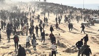Ratusan warga Palestina, termasuk anak-anak, berkumpul dan orang dewasa melakukan salat disela penantian bantuan.  